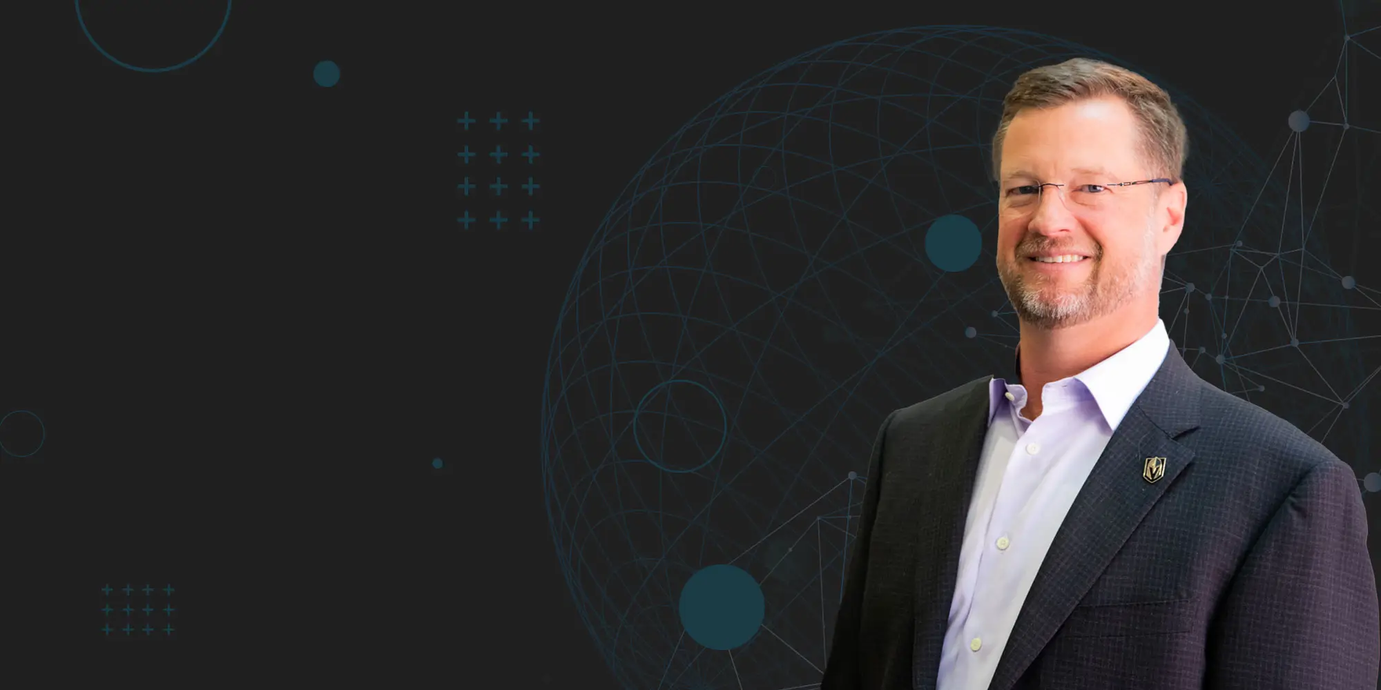 Smiling man wearing glasses and a suit stands against a dark background with a geometric globe and abstract circles, suggesting a professional or technological theme.